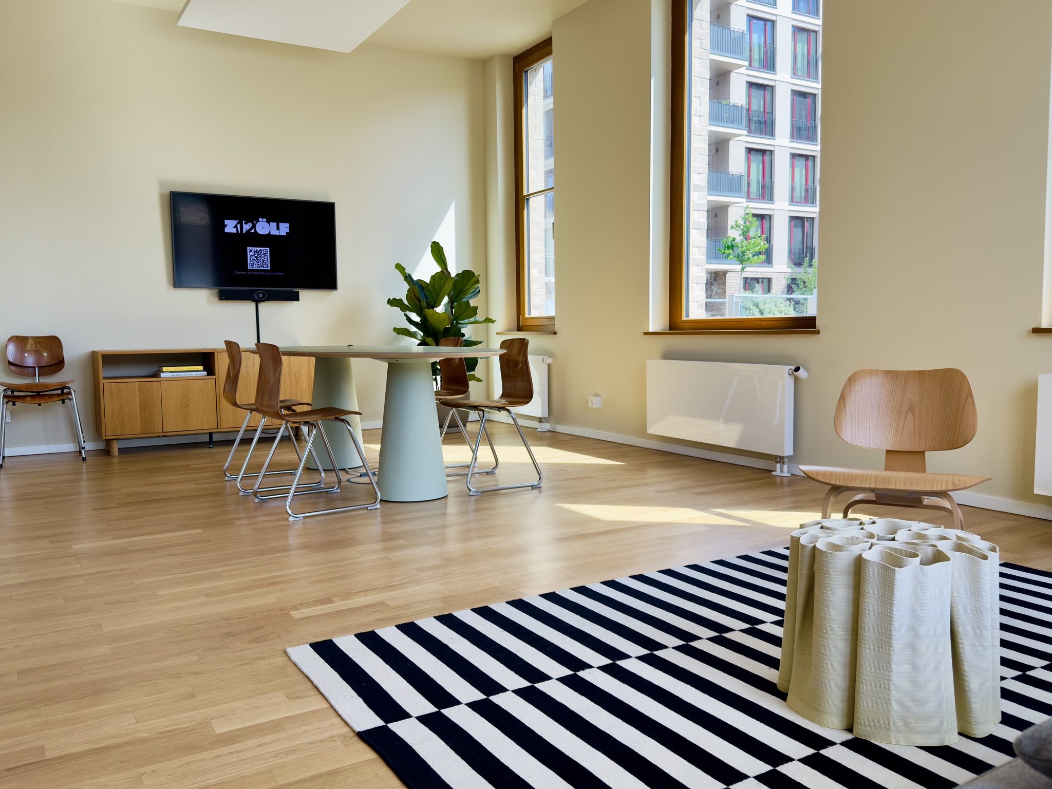 Tisch mit Stühlen, TV-Bildschirm und bodentiefe Fenster